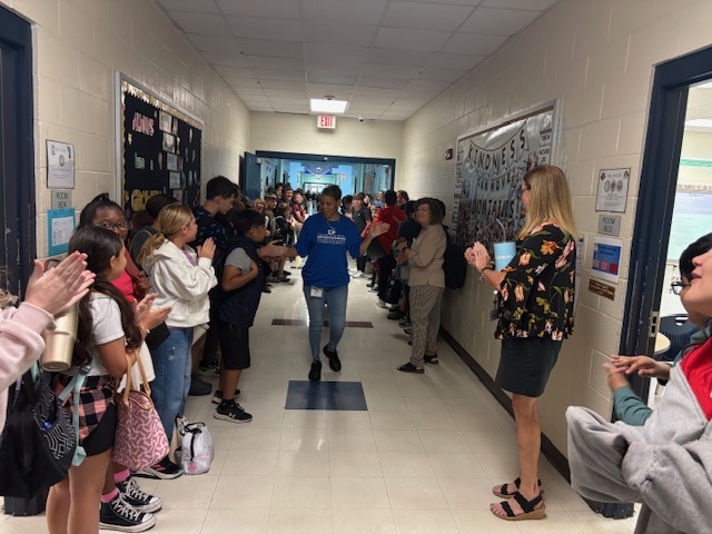 Ms. Brenda walking down the hallway getting high fives for National Custodian Day.