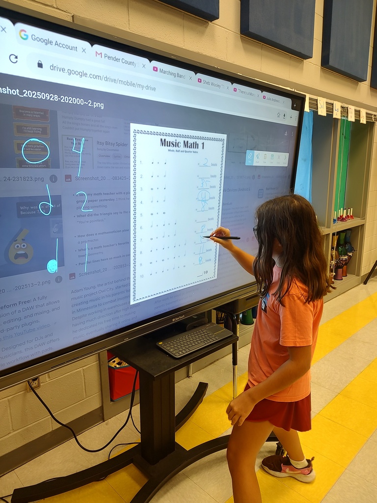 students working on a math and music worksheet on a touch panel
