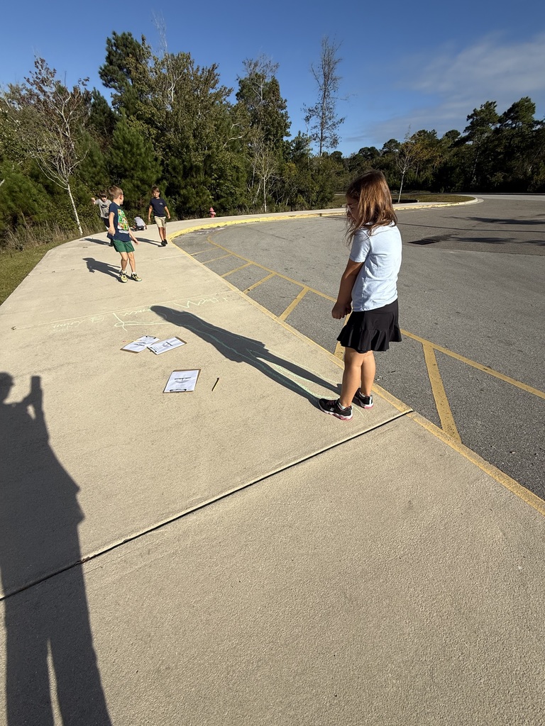 student tracing their shadows outside