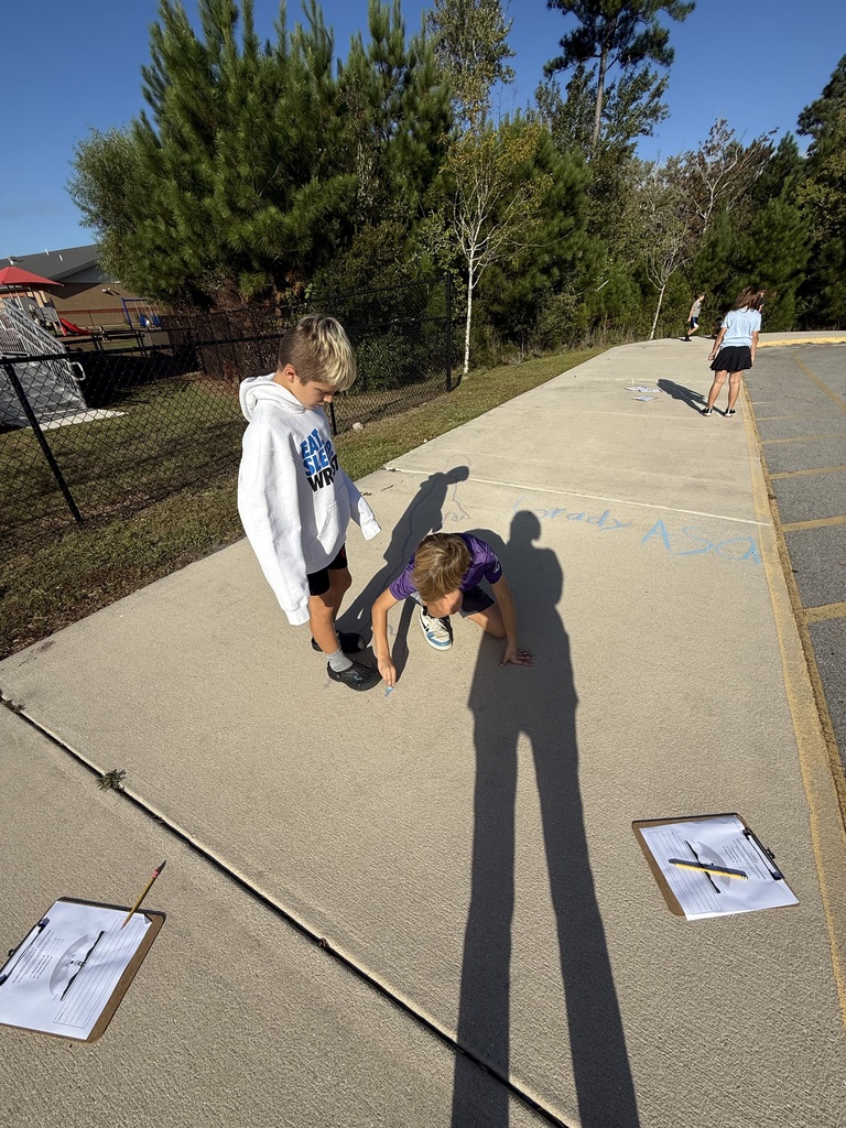 student tracing their shadows outside