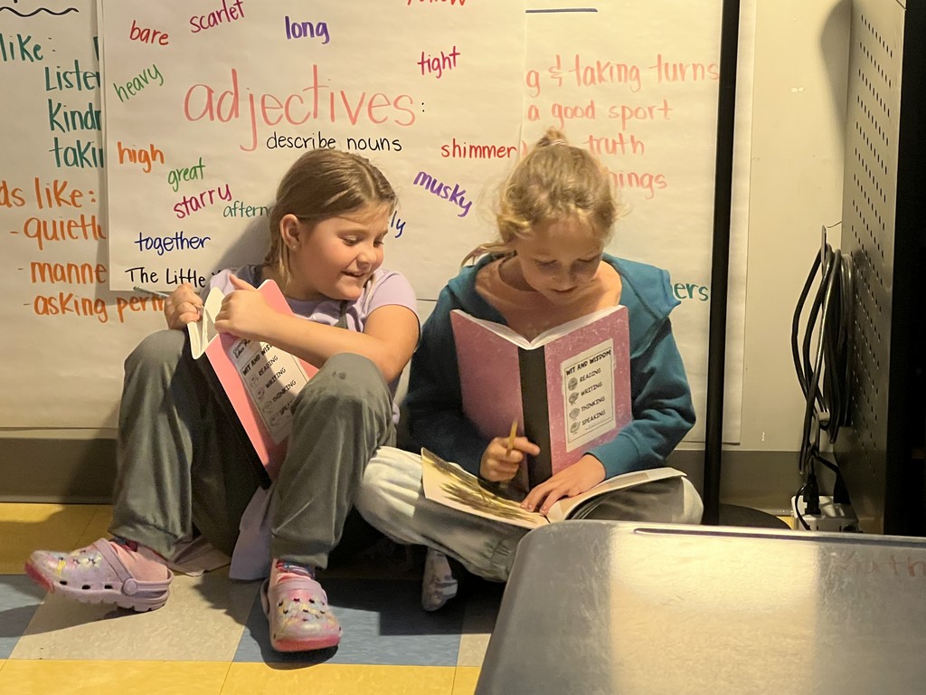 2nd graders sitting on the floor reading together