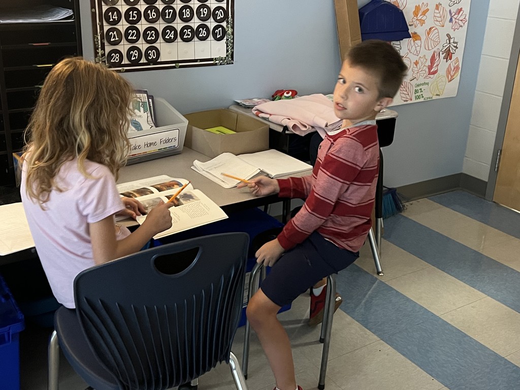 2nd graders sitting on the floor reading together