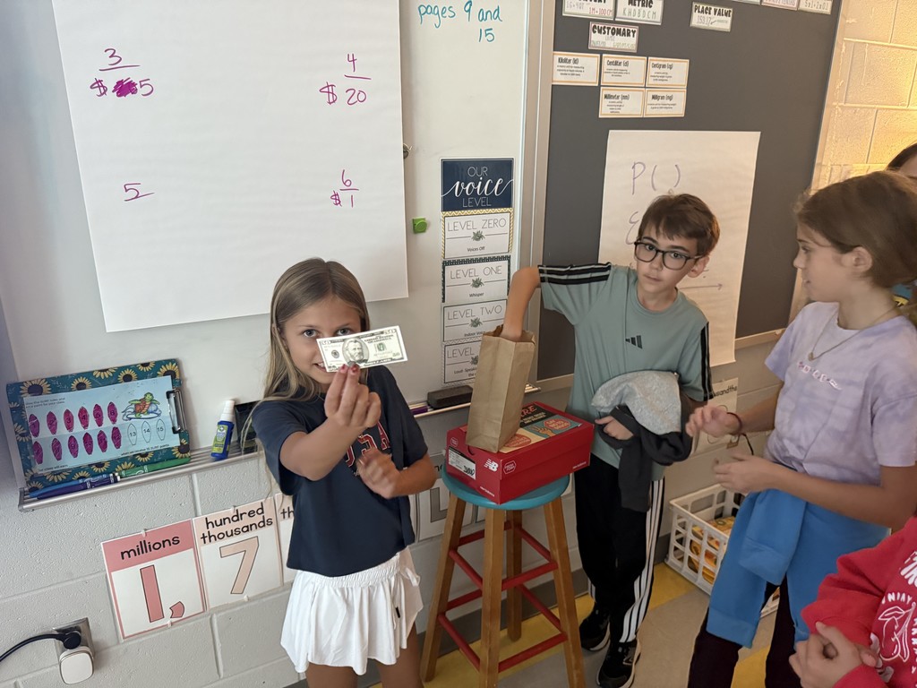 5th graders working in small groups on math problems at their desks