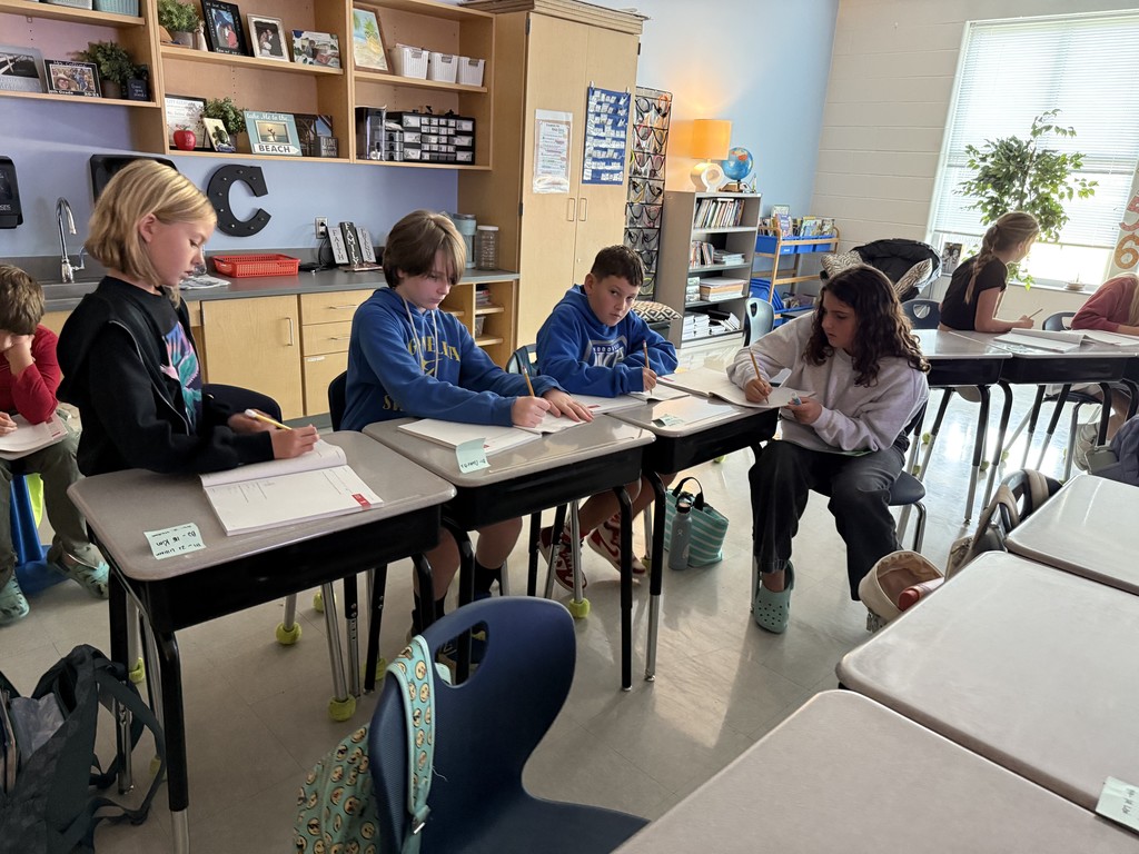 5th graders working in small groups on math problems at their desks