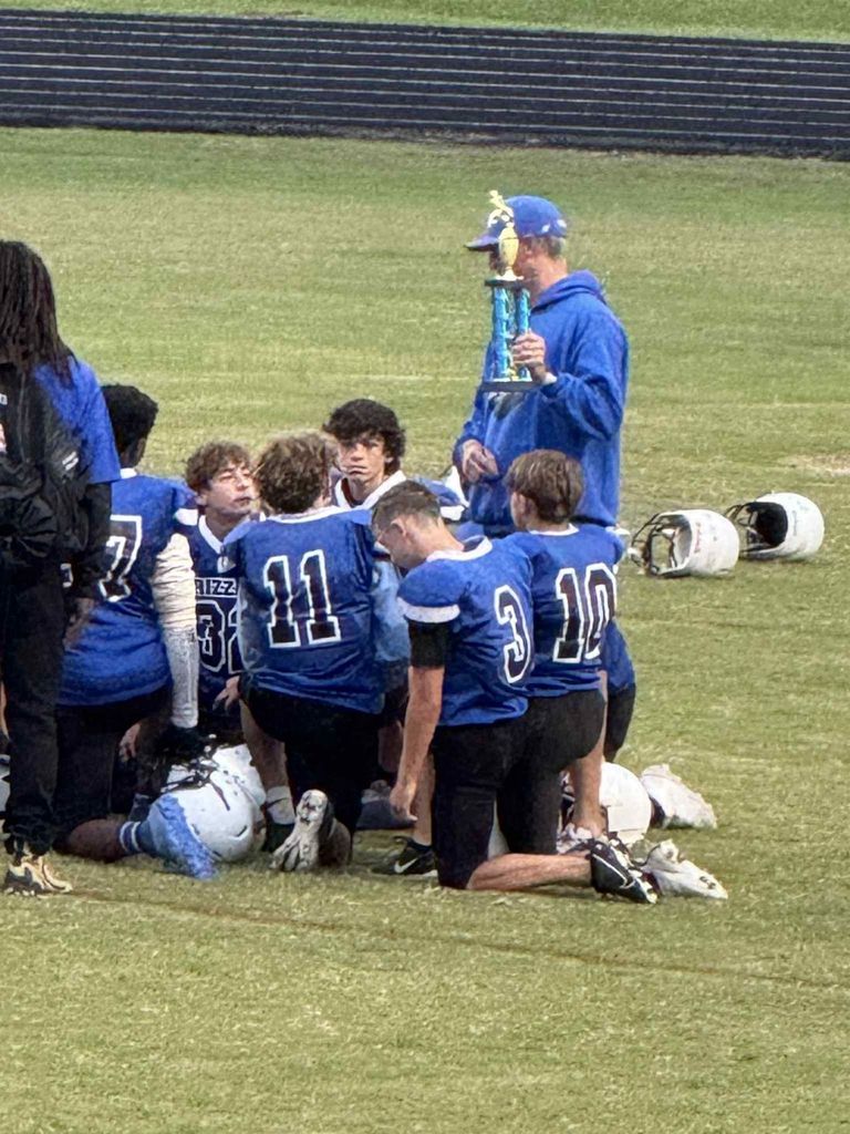 Coach Bell showing the team the championship trophy.