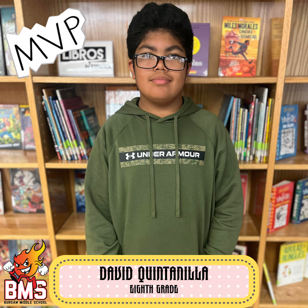 student posing in front of bookshelf with graphics and name