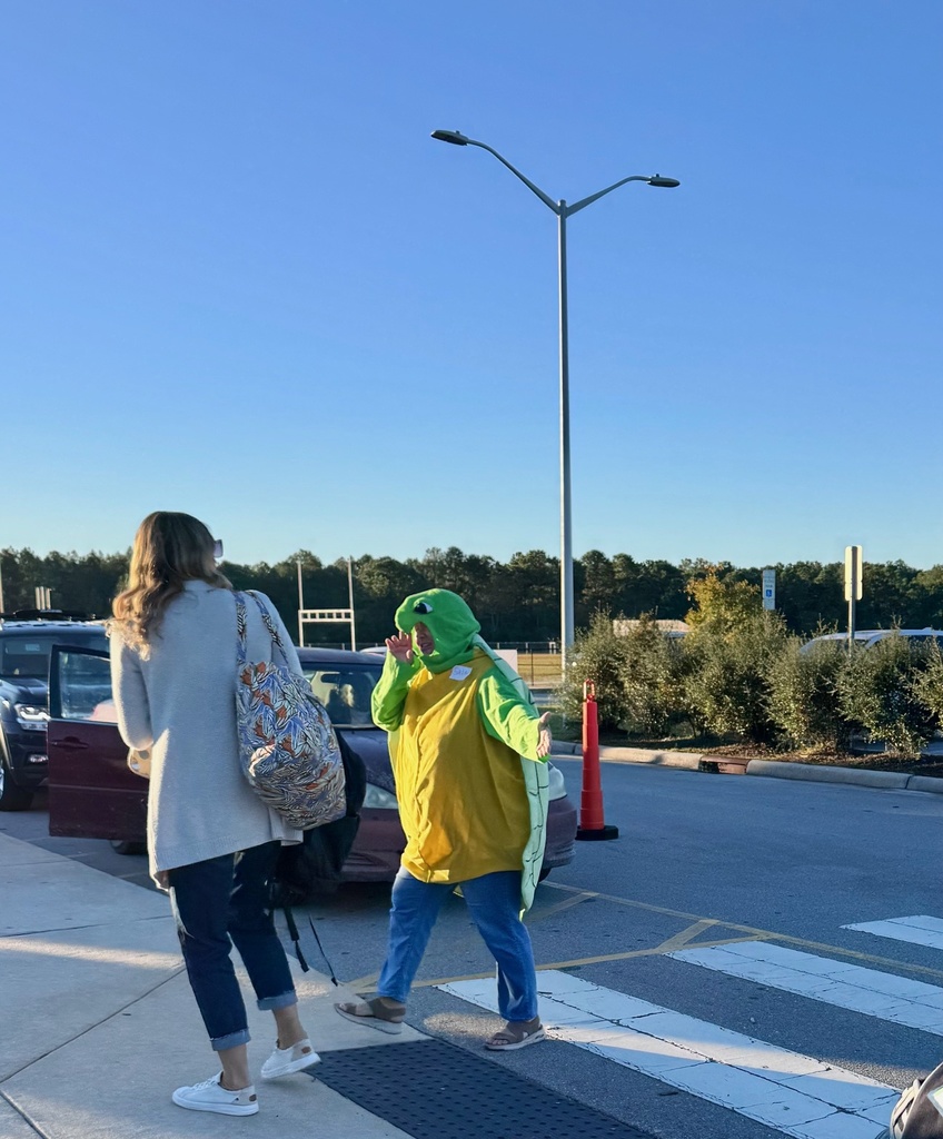 staff member dressed up as a sea turtle welcoming student at the morning car line