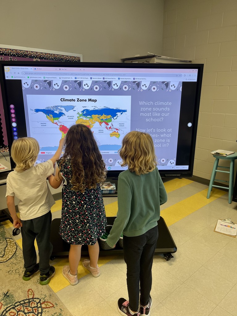 2nd graders holding beach balls with maps on them