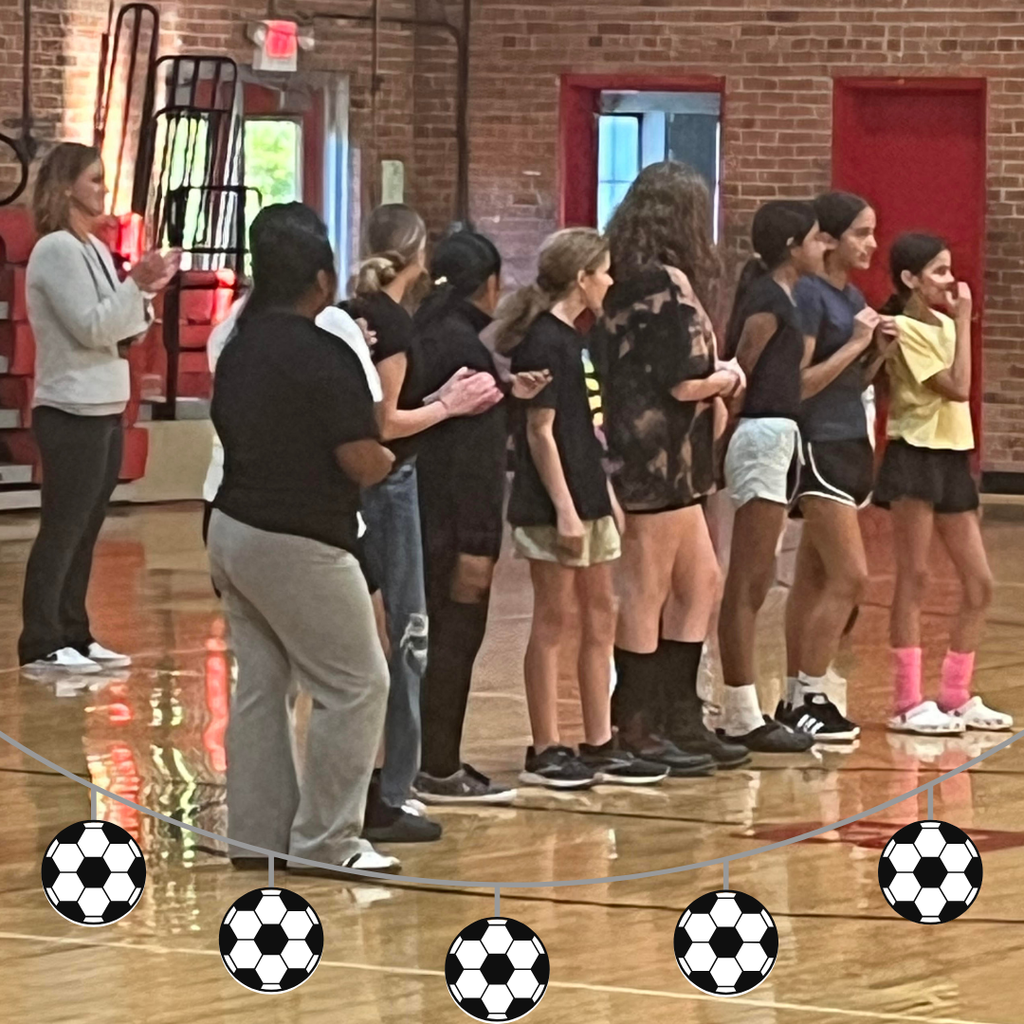 soccer team with coach standing in line in gym