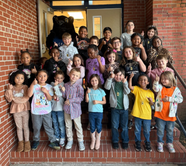 students of the week standing on school steps with the mascot
