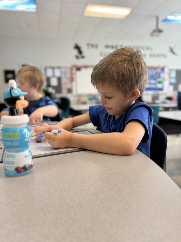 students sitting at a teacher table working on math