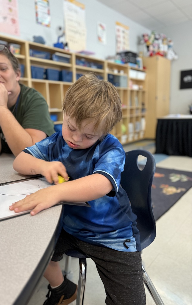 students sitting at a teacher table working on math