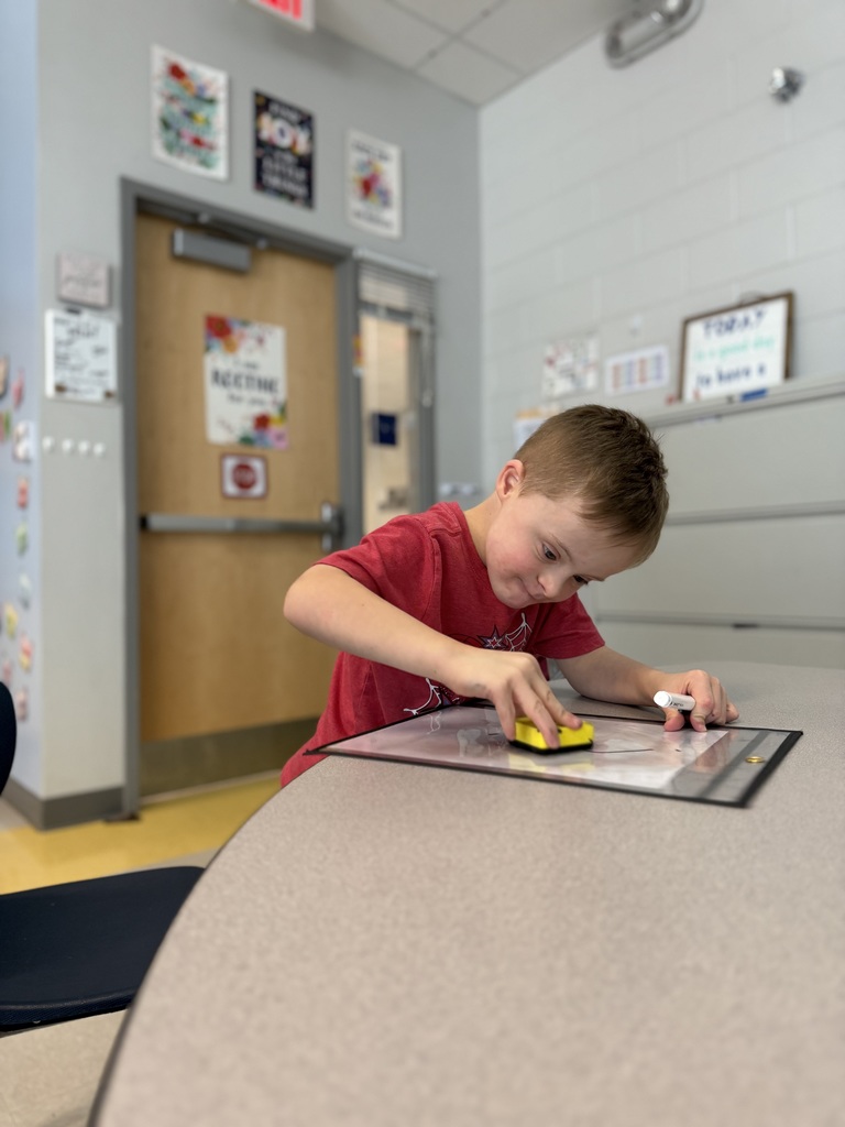 students sitting at a teacher table working on math