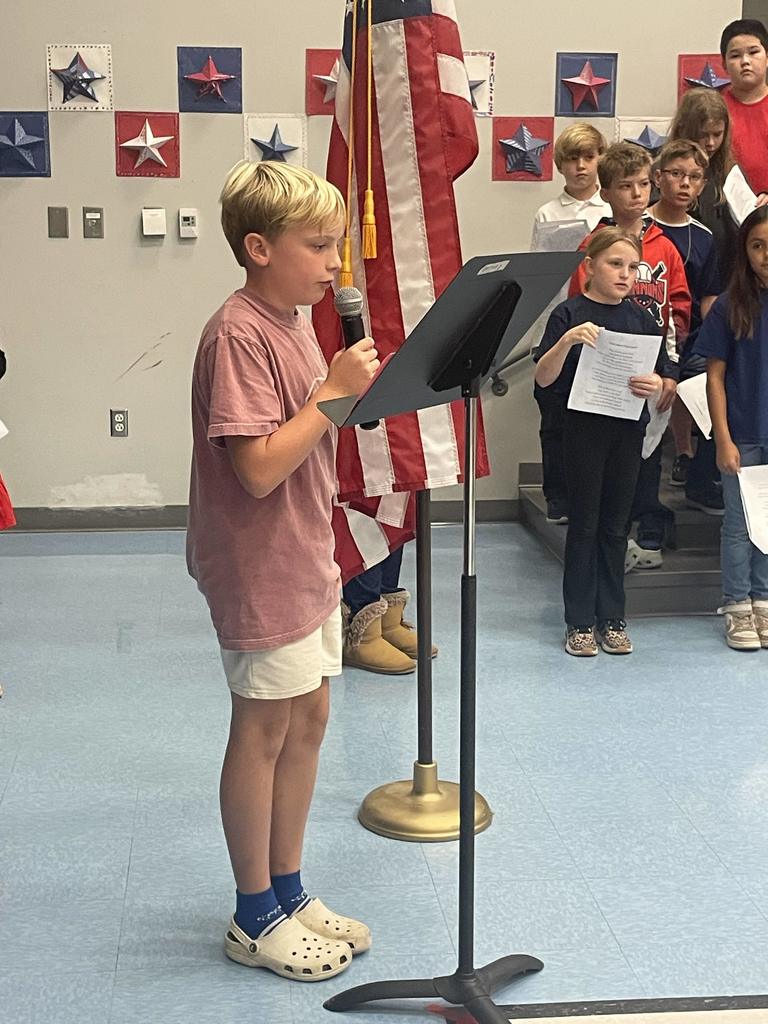 4th grader speaking into a microphone at a concert
