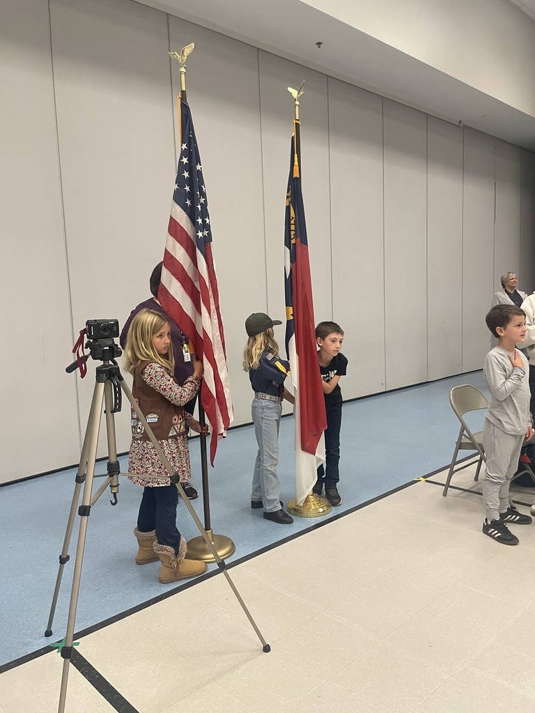 4th grade students walking in the american and state flags at a concert