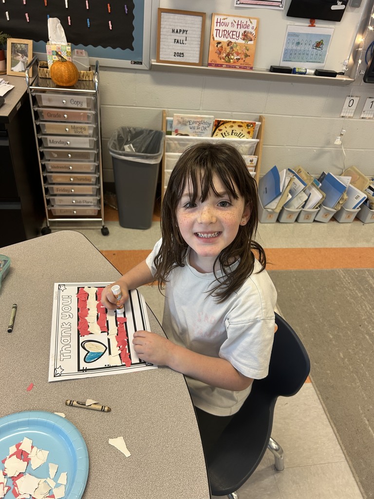 Kindergarten students sitting at their table working on a craft