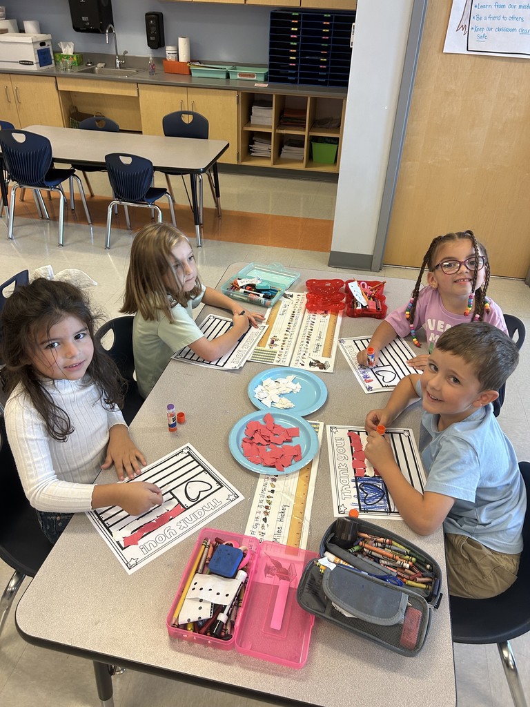 Kindergarten students sitting at their table working on a craft
