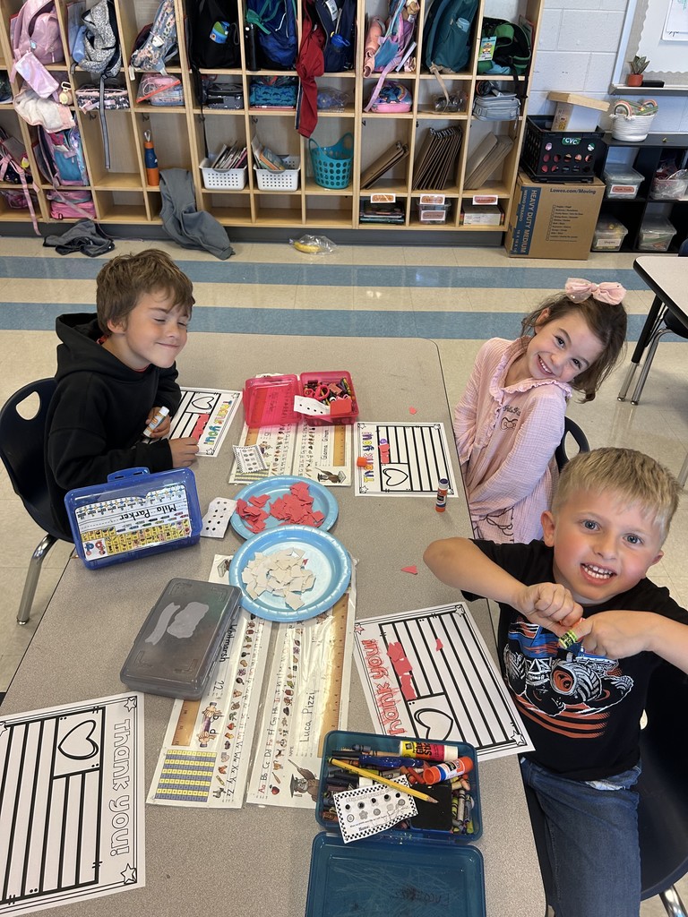 Kindergarten students sitting at their table working on a craft