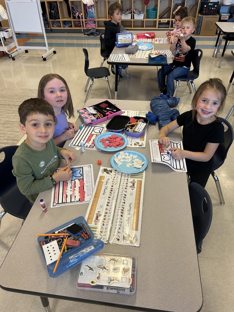 Kindergarten students sitting at their table working on a craft
