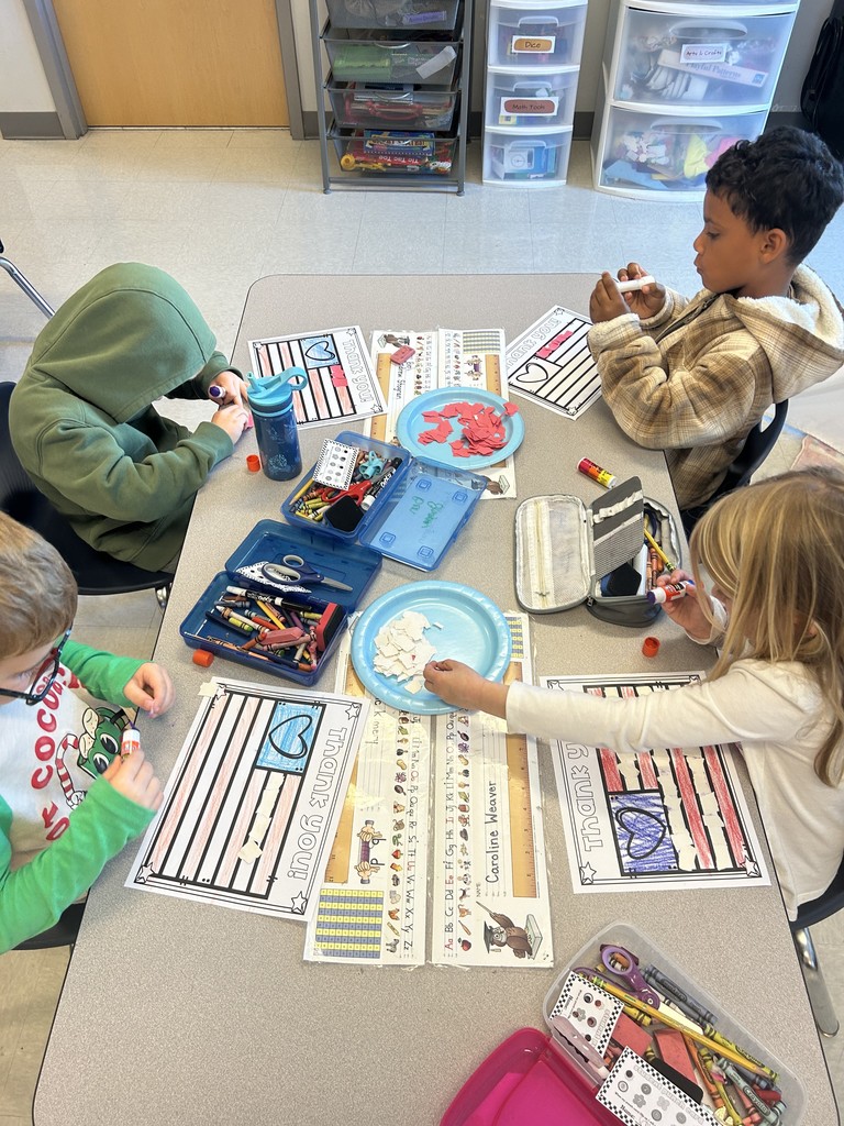 Kindergarten students sitting at their table working on a craft