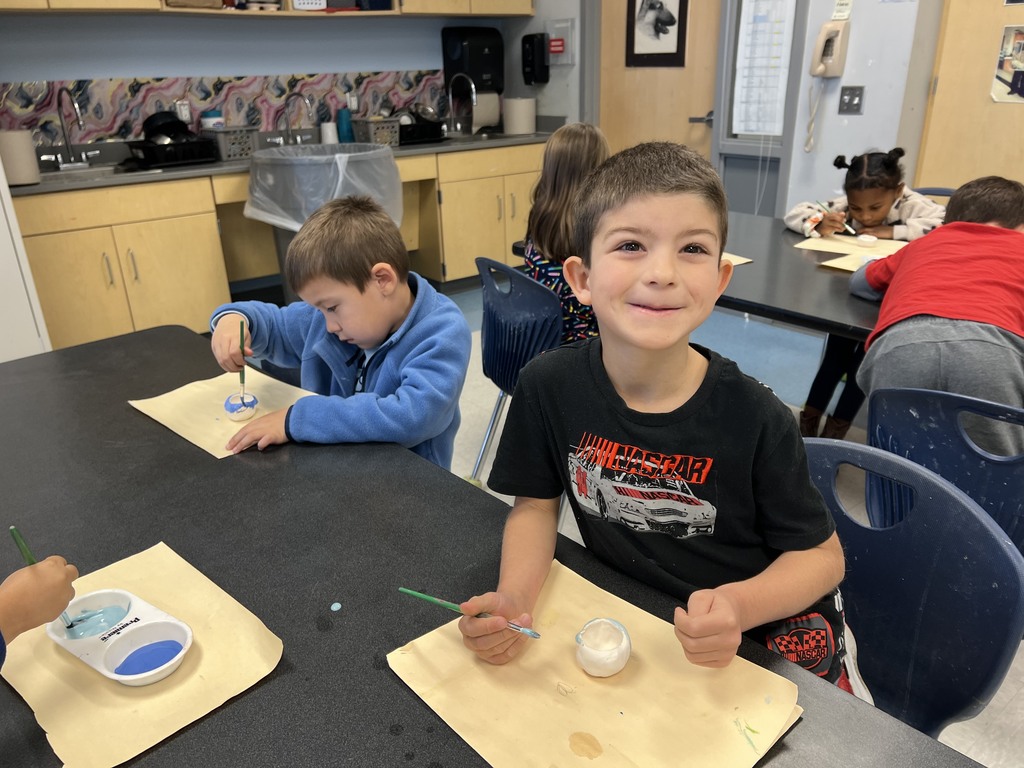 Kindergarten students working at their tables in art class on a clay project