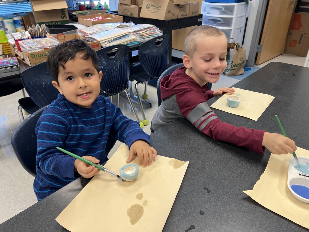 Kindergarten students working at their tables in art class on a clay project