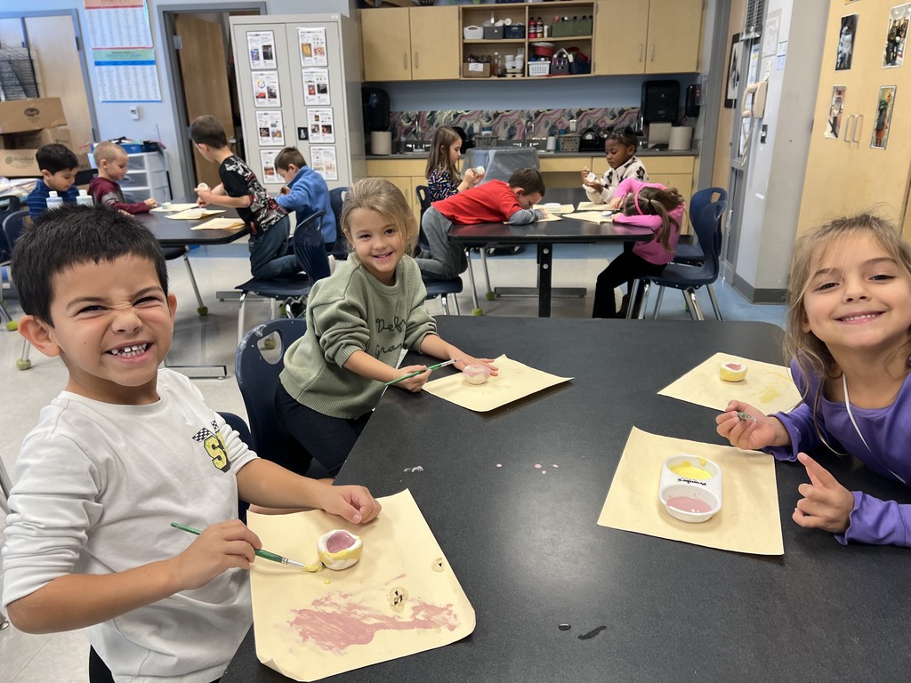 Kindergarten students working at their tables in art class on a clay project
