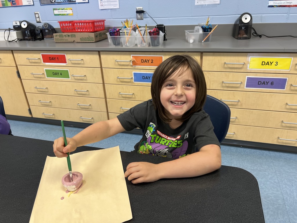 Kindergarten students working at their tables in art class on a clay project