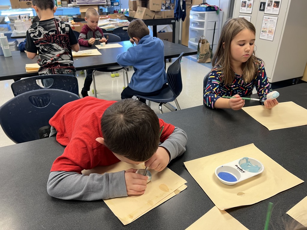 Kindergarten students working at their tables in art class on a clay project