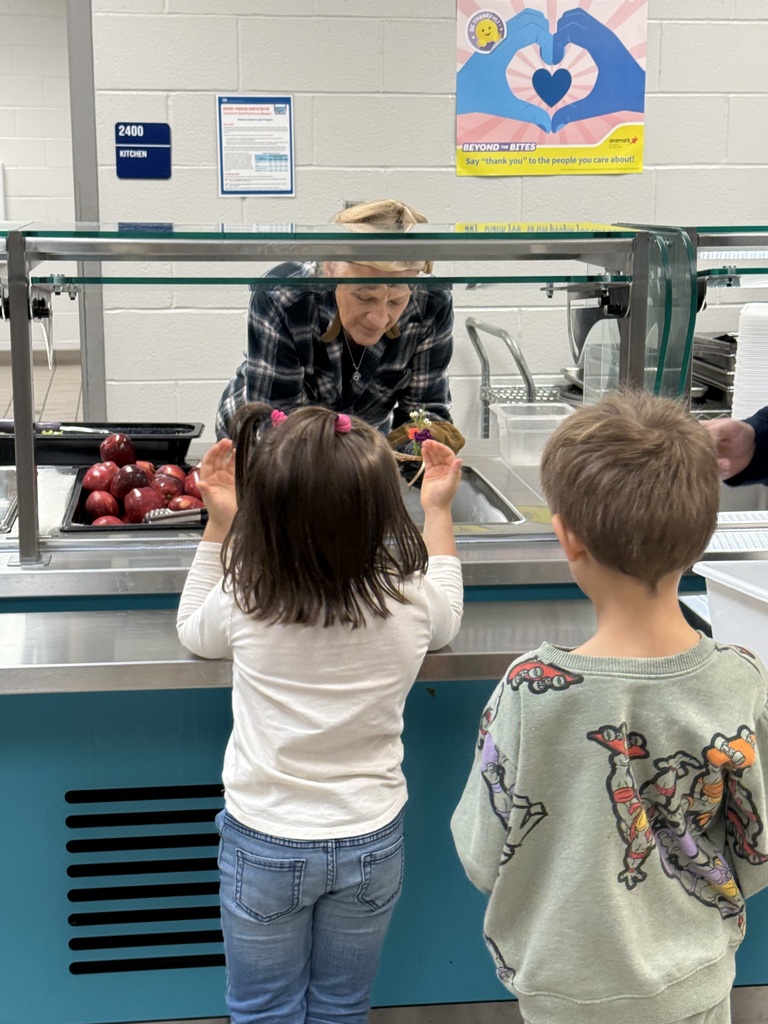 students giving flowers to staff members for world kindness day