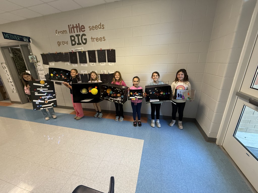 3rd graders holding their solar system projects
