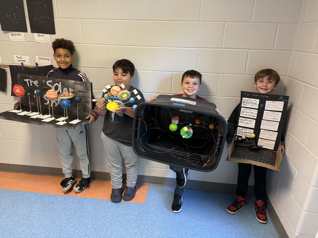 3rd graders holding their solar system projects