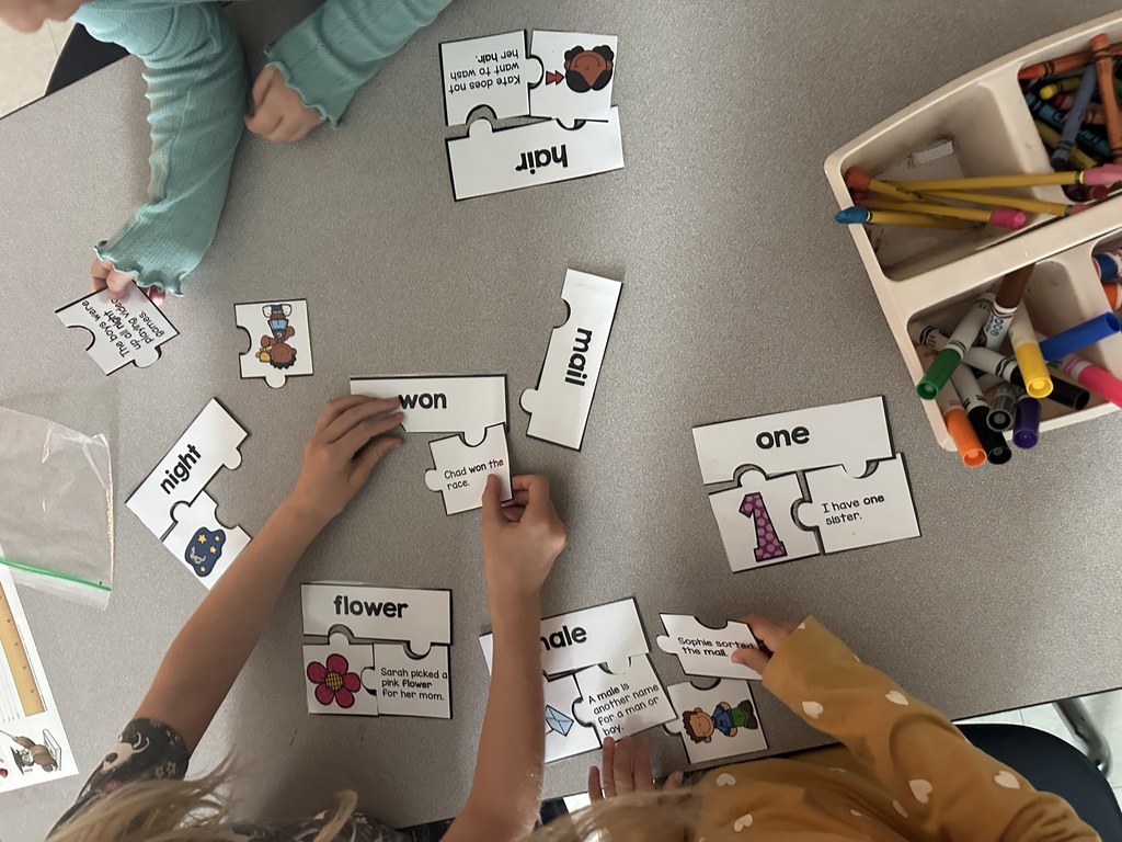 first graders working in groups on a homophone matching activity 