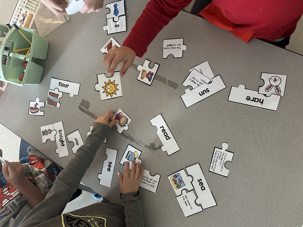 first graders working in groups on a homophone matching activity 