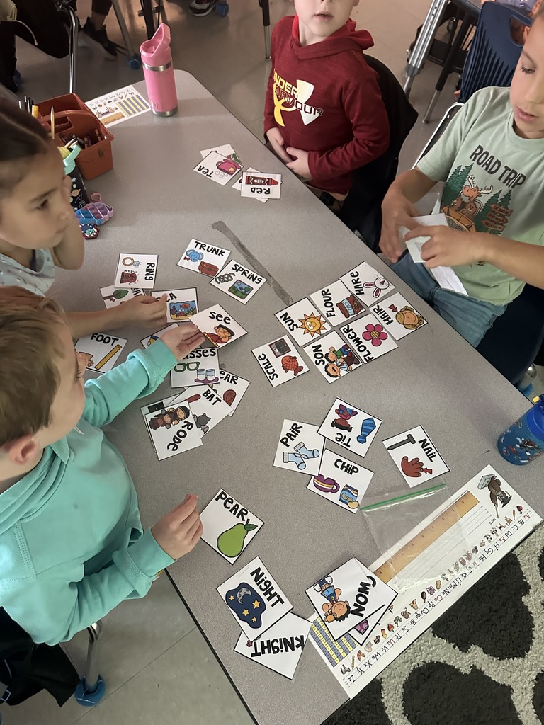 first graders working in groups on a homophone matching activity 