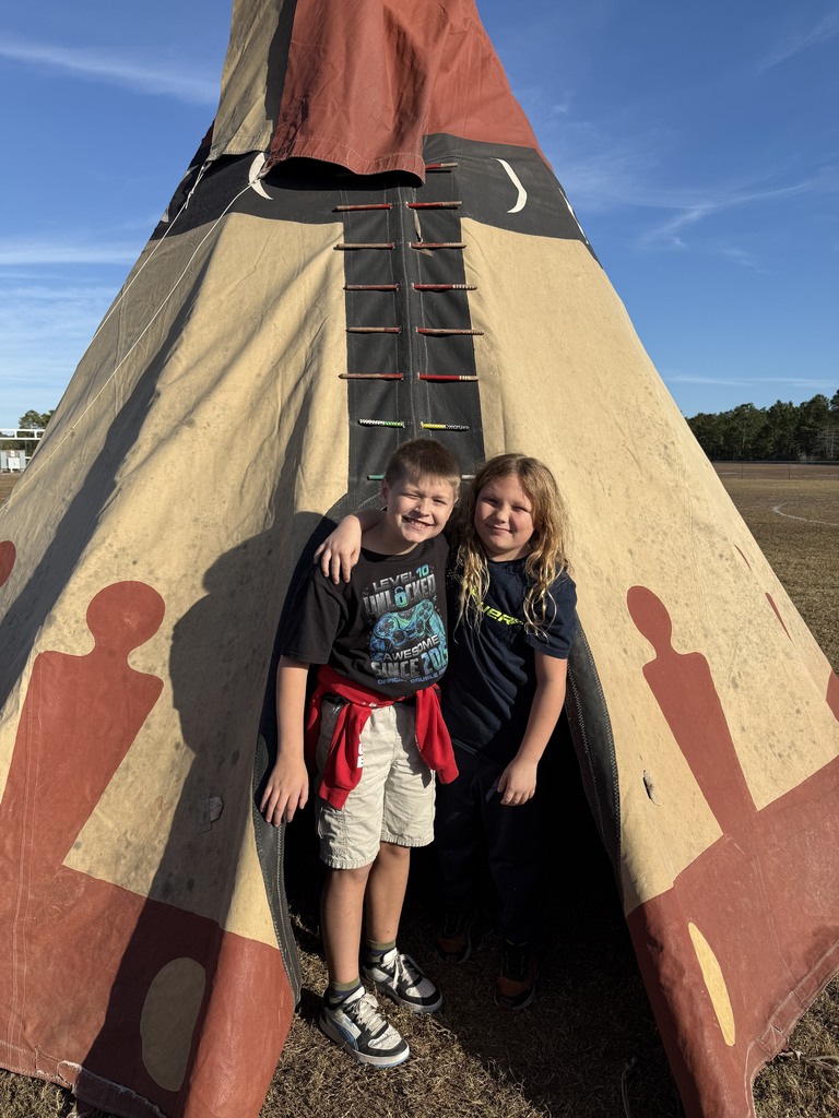 4th grade students standing outside Native American teepee
