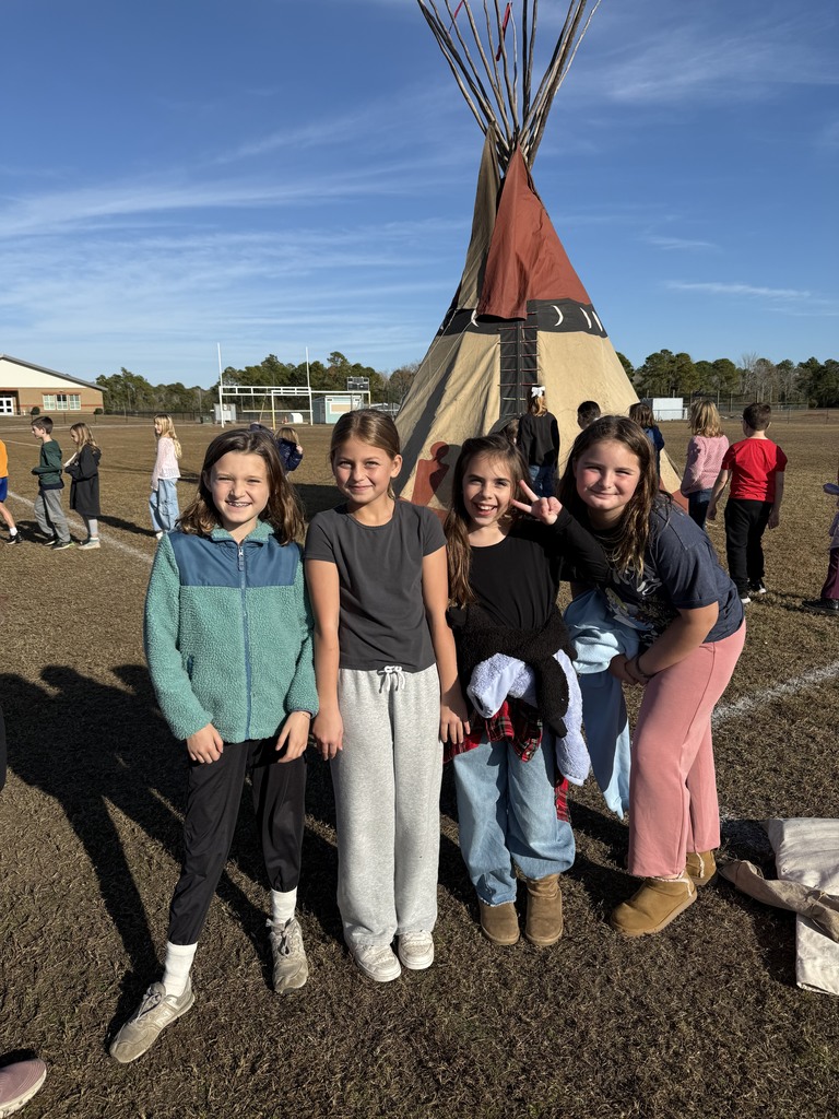 4th grade students standing outside Native American teepee