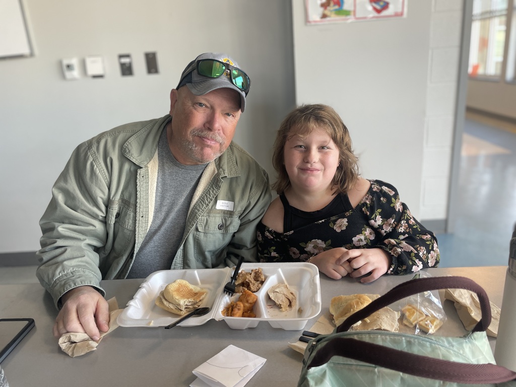 students eating Thanksgiving lunch with their families at school