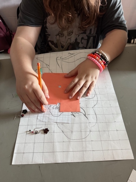 Ms. Patrick's art students using the grid method to enlarge a carton character.