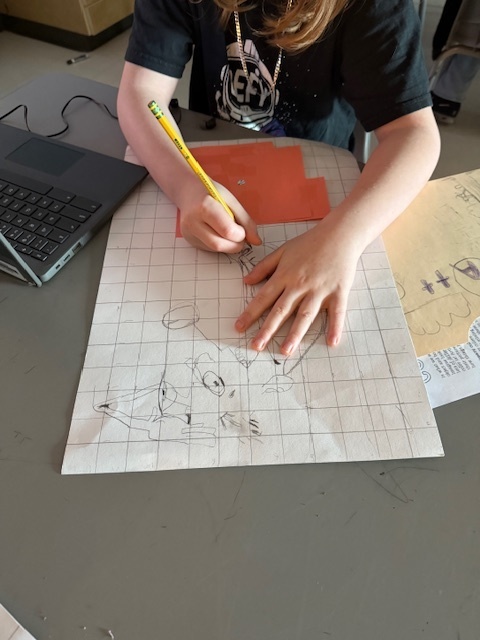 Ms. Patrick's art students using the grid method to enlarge a carton character.