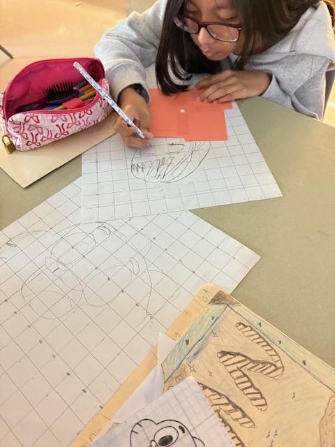Ms. Patrick's art students using the grid method to enlarge a carton character.