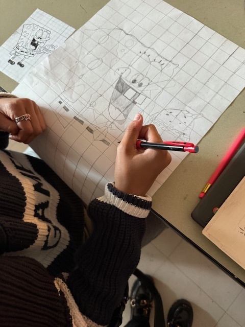 Ms. Patrick's art students using the grid method to enlarge a carton character.