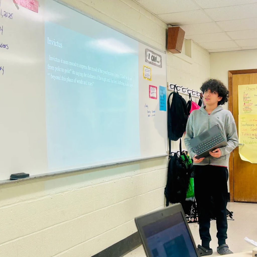 student standing by board and presenting to class