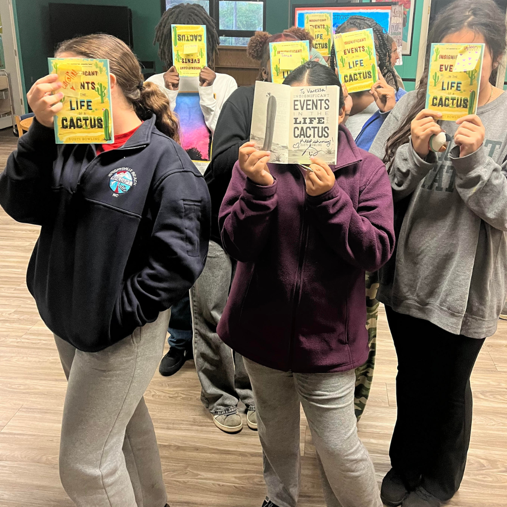 students holding books by author