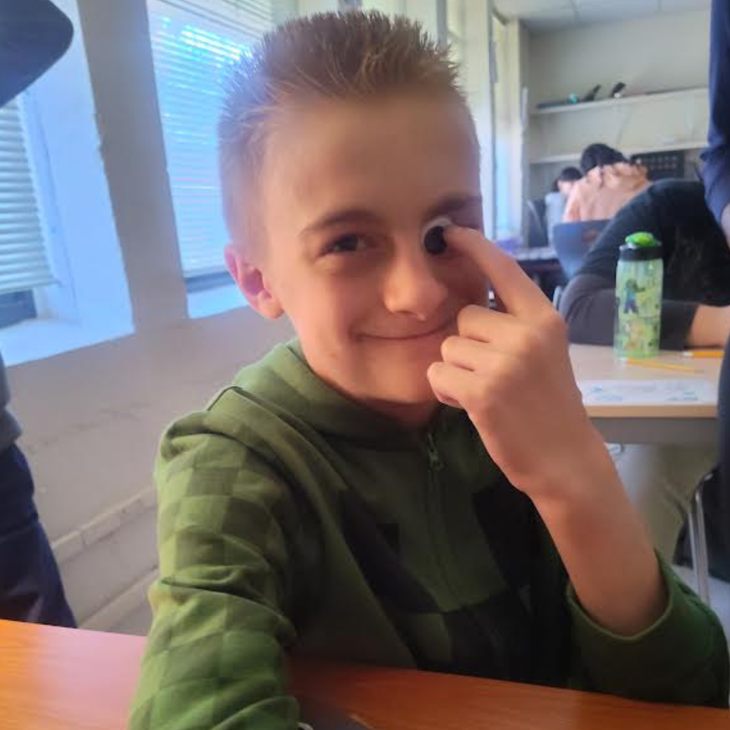 student at table with googly eye