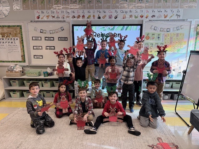 1st graders holding up their reindeer projects 