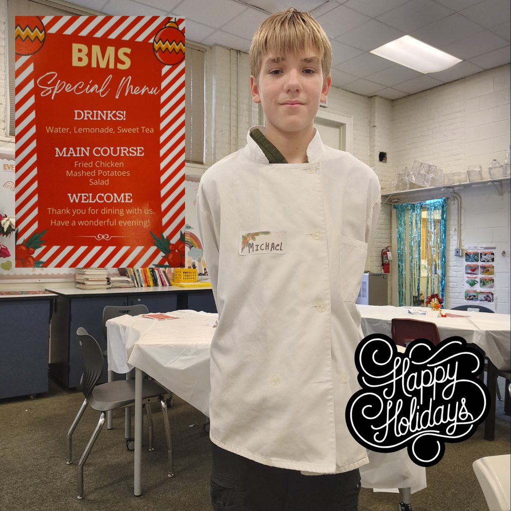 student posing in chef coat with menu