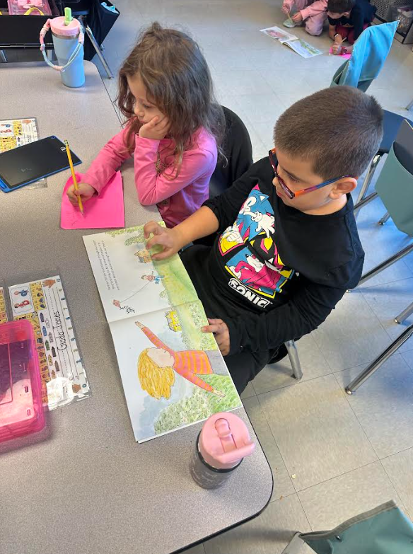1st graders working in partners on a picture walk in a book