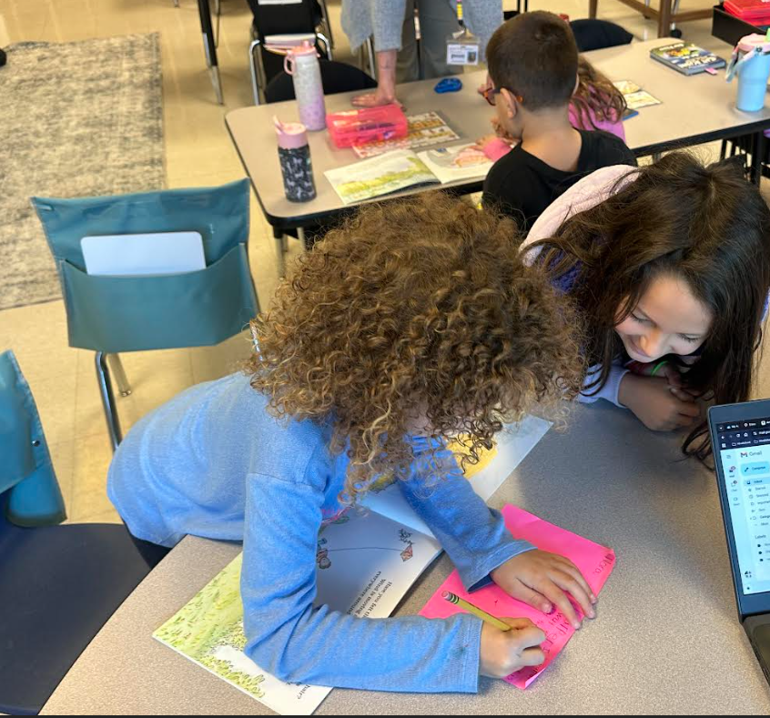 1st graders working in partners on a picture walk in a book