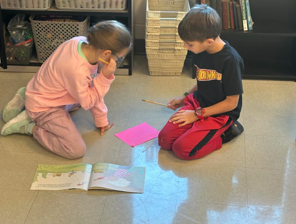 1st graders working in partners on a picture walk in a book
